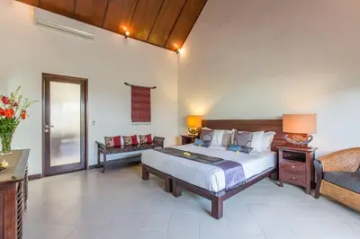 a bedroom with a large bed and a couch at 2 Bedroom Private Pool walking distance to the Seminyak beach in Seminyak