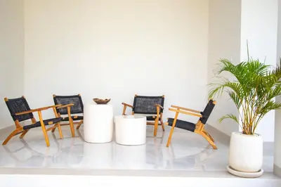 four chairs and a potted plant in a room at Kubung 1 - Villa with HUGE Pool and PS5 in Kerobokan