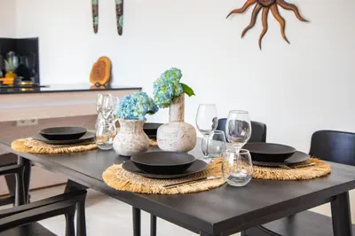a dining room table with black plates and vases at Kubung 1 - Villa with HUGE Pool and PS5 in Kerobokan