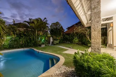 a swimming pool in a yard next to a house at Villa Selamat, Seminyak, Batu Belig, 10 min from beach in Seminyak