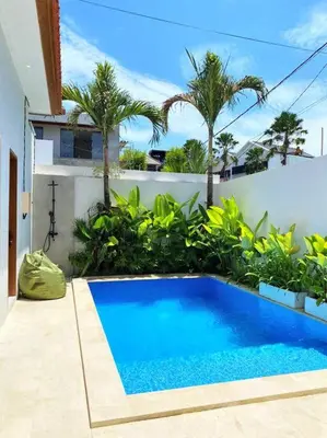 a blue swimming pool in a yard with palm trees at Cosy 2bed/2bath villa 5 min to beach in Dalung