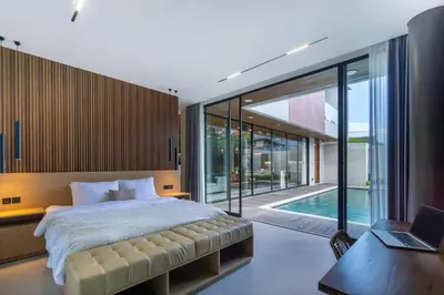 a bedroom with a large bed and a pool at Villa Elena by Maheswara in Seminyak