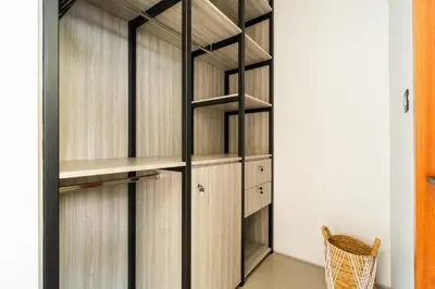 a walk in closet with wooden shelves at Villa Elena by Maheswara in Seminyak