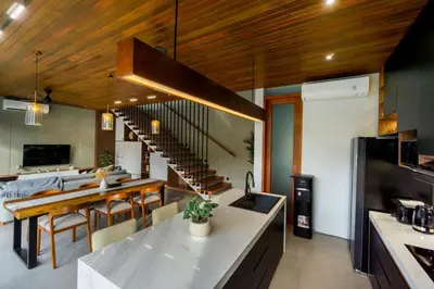 a kitchen and dining room with a spiral staircase at Villa Elena by Maheswara in Seminyak