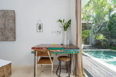 a home office with a table and a swimming pool at Villa Céline 1 Bdr pool Seminyak in Seminyak