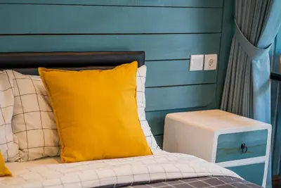 a bed with a yellow pillow and a side table at NEW! Villa Sony 2 - 3BR villa next to Legian Beach in Seminyak