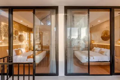 two beds in a room with glass walls at Vin Villa Seminyak 2BR with Private Pool in Seminyak