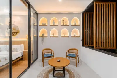a room with a bed and a table and chairs at Vin Villa Seminyak 2BR with Private Pool in Seminyak