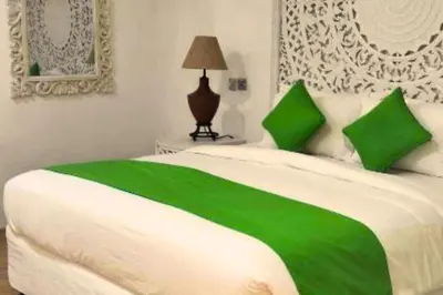 a green and white bed with green pillows on it at Hazel Azalea 4 BR Private Pool Villa in Seminyak