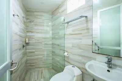 a bathroom with a toilet and a sink and a mirror at House Lizard 3 BR Private Pool Villa in Kerobokan