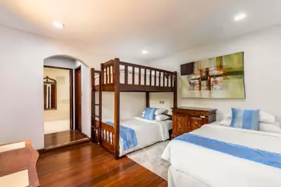 a bedroom with two bunk beds and a mirror at House Lizard 3 BR Private Pool Villa in Kerobokan