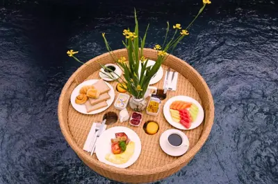 a round table with breakfast foods and a vase of flowers at Lavender 1 BR Private Pool Villa in Seminyak