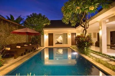 a villa with a swimming pool at night at Ageratum 4 BR Villa Private Pool in Seminyak