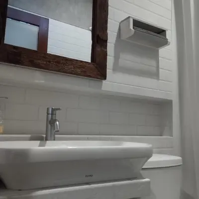 a bathroom with a sink and a mirror and a toilet at Jimbaran Beauteous Villa in Jimbaran