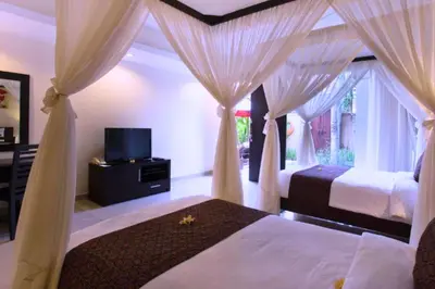 a bedroom with two beds with curtains and a television at Dahlia Mentari 2 BR Private Pool Villa in Seminyak