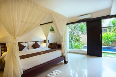 a bedroom with a bed with a canopy at Allamanda 3 BR Private Pool Villa in Seminyak