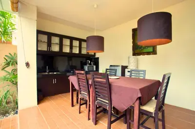 a kitchen and dining room with a table and chairs at Allamanda 3 BR Private Pool Villa in Seminyak