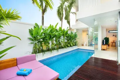 a living room with a swimming pool and a pink couch at Modern 3 BR Private Pool Villa in Legian