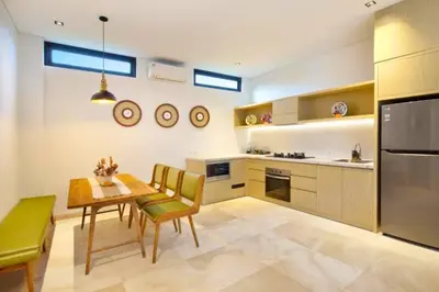 a kitchen with a table and chairs and a dining room at Modern 3 BR Private Pool Villa in Legian