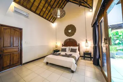 a bedroom with a bed and a large window at Villa JES - 4 Bedroom Villa - Legian in Legian