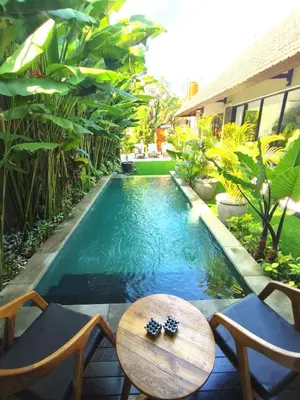 a swimming pool in a backyard with a table and chairs at Villa JES - 4 Bedroom Villa - Legian in Legian