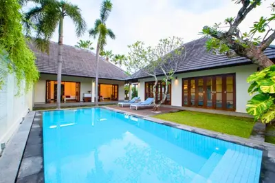 a swimming pool in front of a house at Cozy 2 BR Private Pool Villa in Seminyak