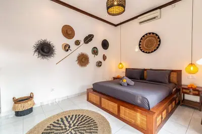 a bedroom with a bed and some items on the wall at Cosy Traditional and Fresh 2 BD Sunterrace Villa with Pvt Pool in Kerobokan