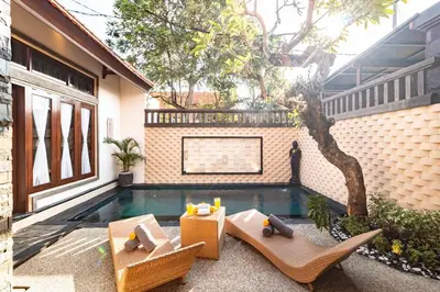 a backyard with a pool with chairs and a tree at Cosy Traditional and Fresh 2 BD Sunterrace Villa with Pvt Pool in Kerobokan