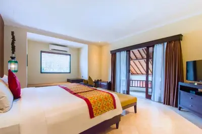 a hotel room with a bed and a television at Entire 2 BR Private Pool Villa in Seminyak
