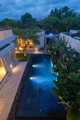 a swimming pool in the backyard of a house at night at Rekso Villa in Jimbaran