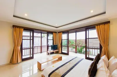 a bedroom with a large bed and large windows at Entire 3 BR Private Pool Villa in Seminyak