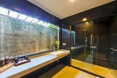 a bathroom with a shower and a sink and a mirror at Entire 3 BR Private Pool Villa in Seminyak