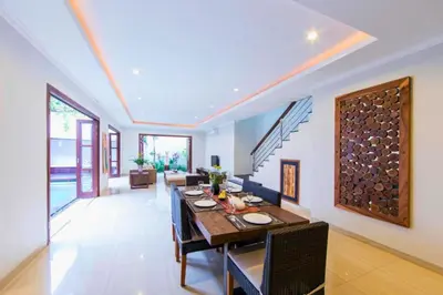 a dining room and living room with a table and chairs at Entire 3 BR Private Pool Villa in Seminyak