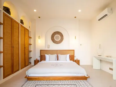 a bedroom with a large bed and a fireplace at Casa Pelagos in Kerobokan