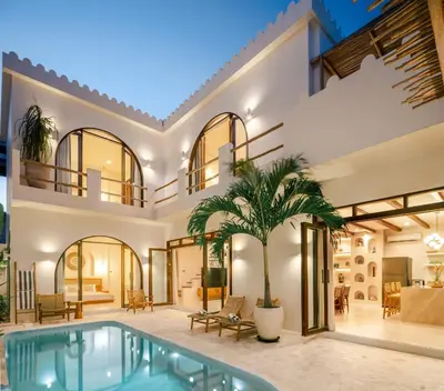 a home with a swimming pool and a house at Casa Pelagos in Kerobokan