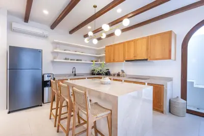 a kitchen with a large island and a refrigerator at Casa Pelagos in Kerobokan