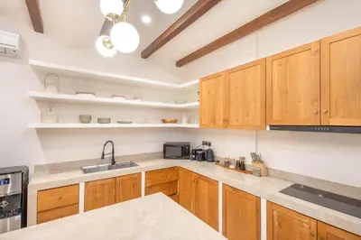 a kitchen with wooden cabinets and a sink at Casa Pelagos in Kerobokan