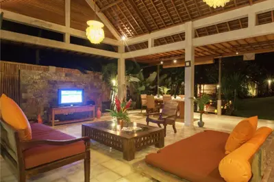 a living room with a couch and a tv on a patio at Clover 3 BR Private Pool Villa in Canggu