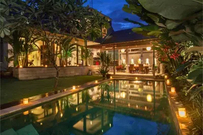a house with a swimming pool with lights in the yard at Clover 3 BR Private Pool Villa in Canggu