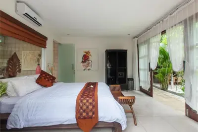 a bedroom with a large bed and a balcony at Clover 3 BR Private Pool Villa in Canggu