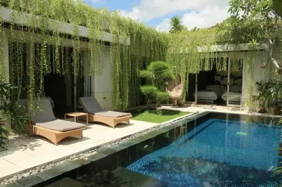 a backyard with a swimming pool with a pergola at Vlad Bali Villa in Jimbaran