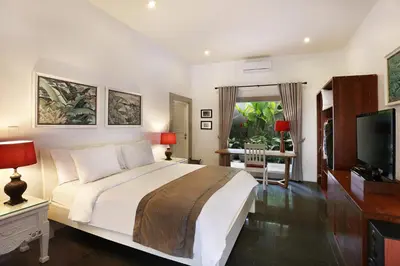 a bedroom with a large bed and a television at Villa Viona 4 in Seminyak