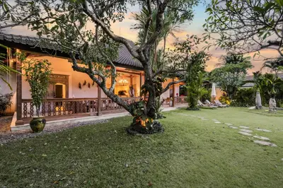 a house with a tree in the yard at Villa Kuda Sumba by BaliSuperHost in Kerobokan