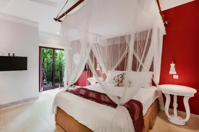 a bedroom with a white bed with a canopy at Villa Kuda Sumba by BaliSuperHost in Kerobokan