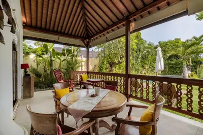 a dining room with a table and chairs on a balcony at Villa Kuda Sumba by BaliSuperHost in Kerobokan