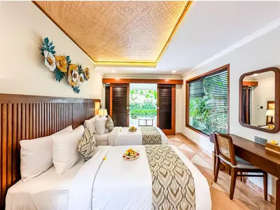 a hotel room with two beds and a desk at Ghana Villa Seminyak by GenuineHost in Seminyak
