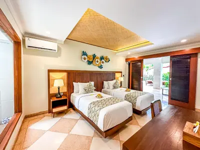 a bedroom with two beds and a table at Ghana Villa Seminyak by GenuineHost in Seminyak