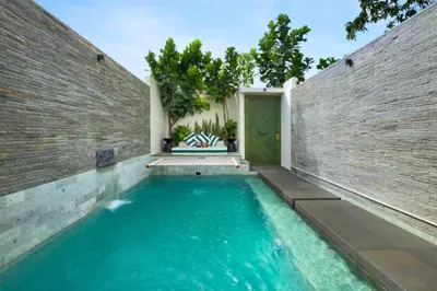 a swimming pool in front of a brick wall at Romantic 1BR Private Pool Villa in Kerobokan