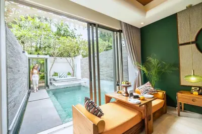 a villa with a pool and a woman walking into the room at Romantic 1BR Private Pool Villa in Kerobokan