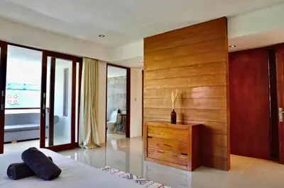 a bedroom with a bed and a wooden wall at Spacious 2 BR Private Pool Villa ZN108 in Seminyak